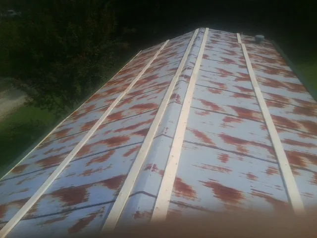 Rusted metal roof panels with new wood purlins before replacement — Storm Damage Roof Repair in Conshohocken by Roofing Brothers