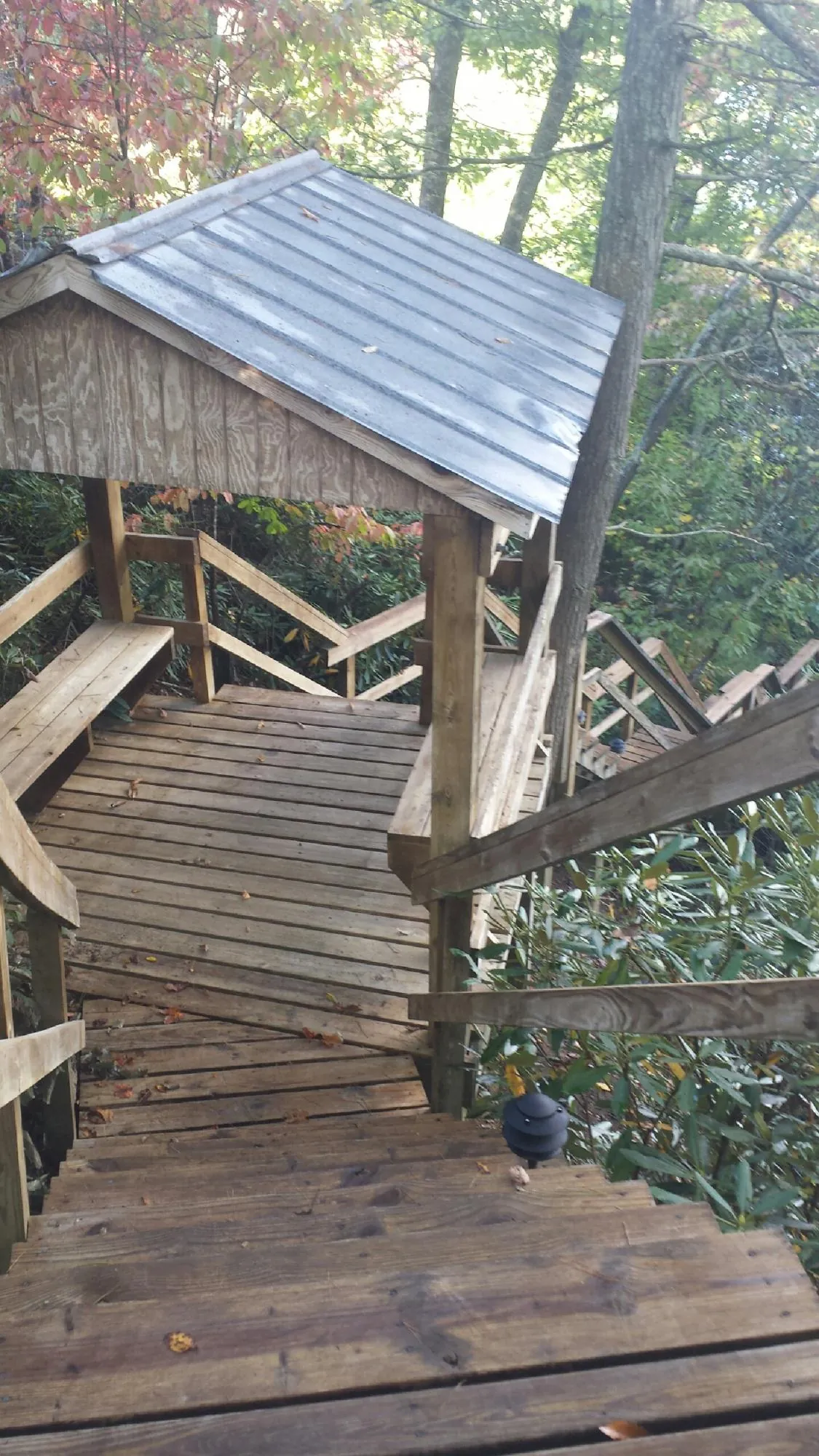 Metal roofed shelter over wooden steps on a wooded walkway — Skylight Repair & Installation work by our crew in Conshohocken