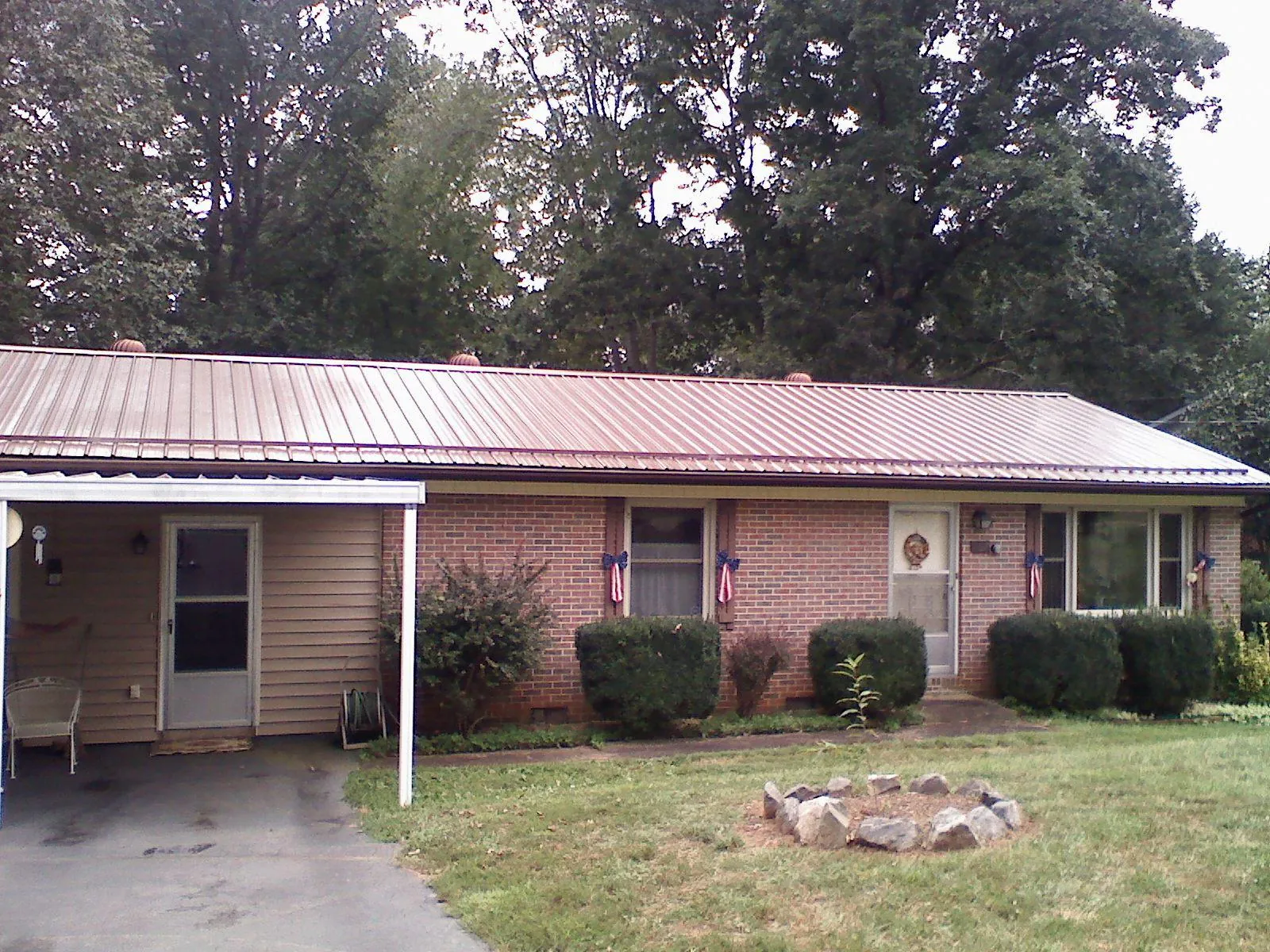 Bronze metal roof and carport on a brick ranch home — Roof Repair work by our crew in Conshohocken